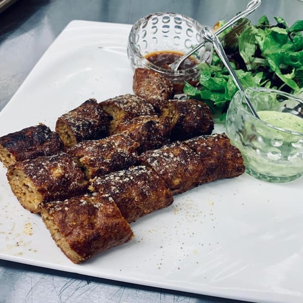 Indian seekh kebabs, dusted with spices, served with green salad, and two dipping sauces.